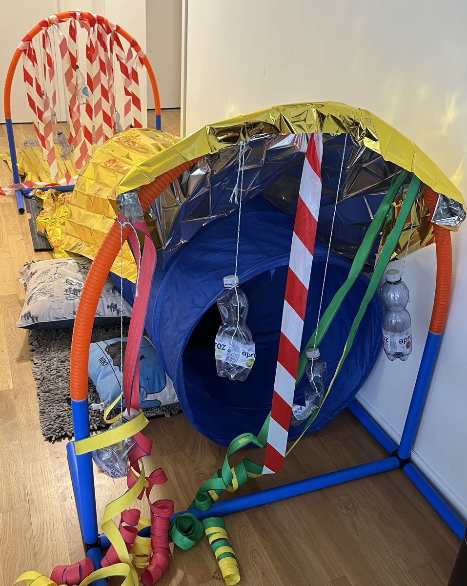 Der selbstgebaute Indoor-Parcours aus Rohren, Absperrband, bunten Bändern und goldener Rettungsdecke im Wohnzimmer.