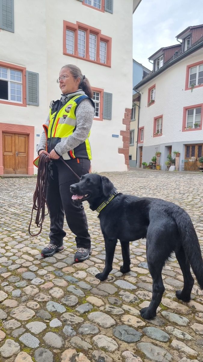 Manuela steht mit Nino in einer Gasse der Rheinfelder Altstadt, Nino blickt aufmerksam zur Seite.